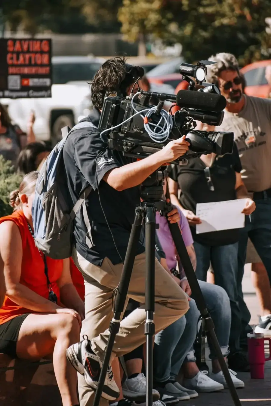 A camera operator filming a public gathering